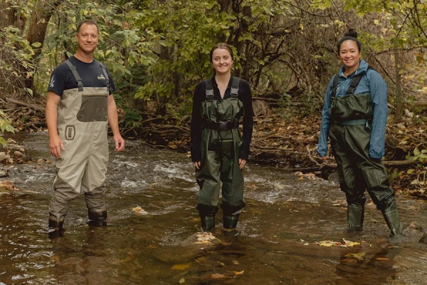 Trevor Pitcher, student Bri Curtis, and Catherine Febria stand in a stream in the Greater Toronto Area home to the redside dace. Photo by Shayenna Nolan.